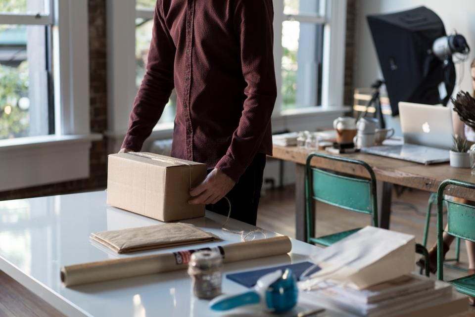 Paket wird am Schreibtisch verpackt
